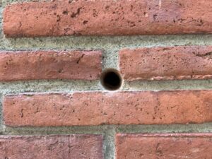 Mur de rajol amb forat per insuflar