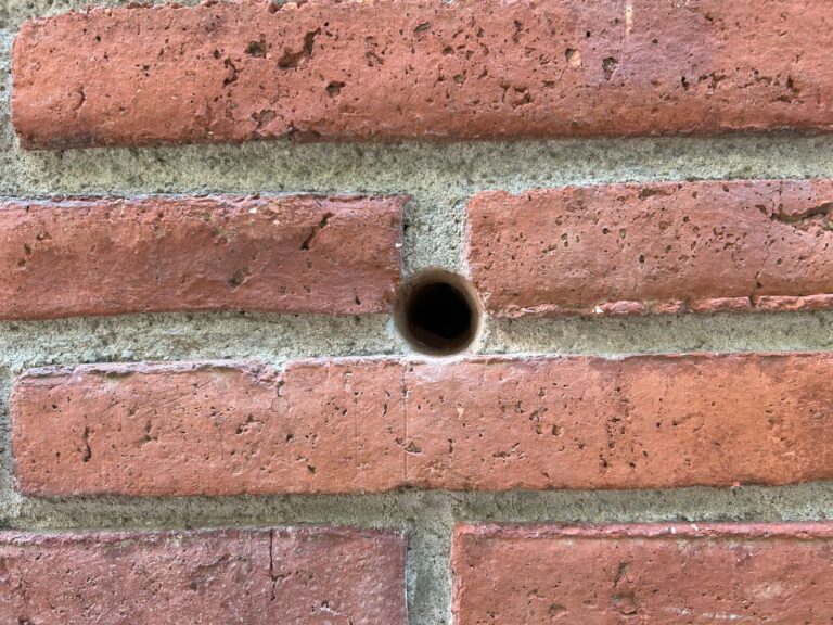 Mur de rajol amb forat per insuflar